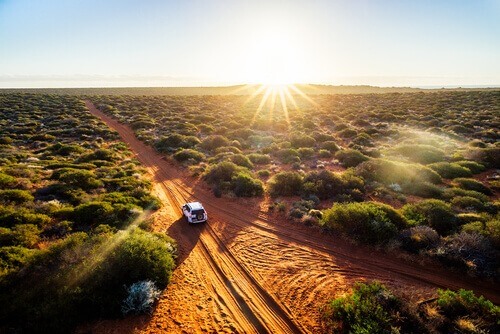 4WD Driving Tips - Australia red sand unpaved road and 4x4 at sunset