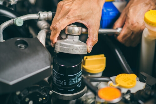 Technician changing engine oil filter on Subaru forester - City Subaru Service