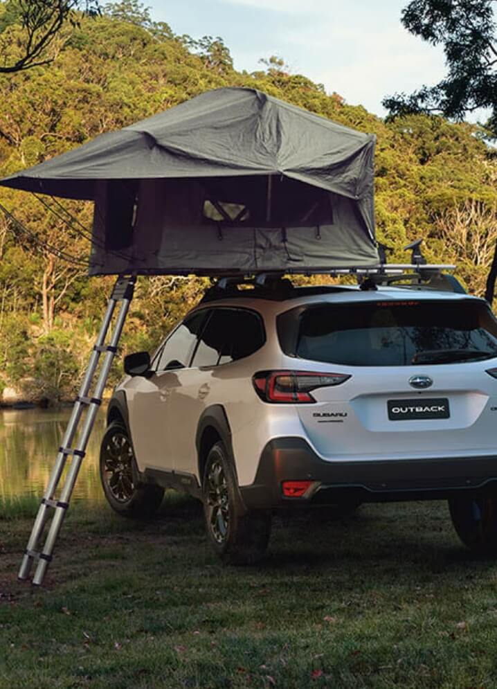 SUV equipped with rooftop camping tent outdoors