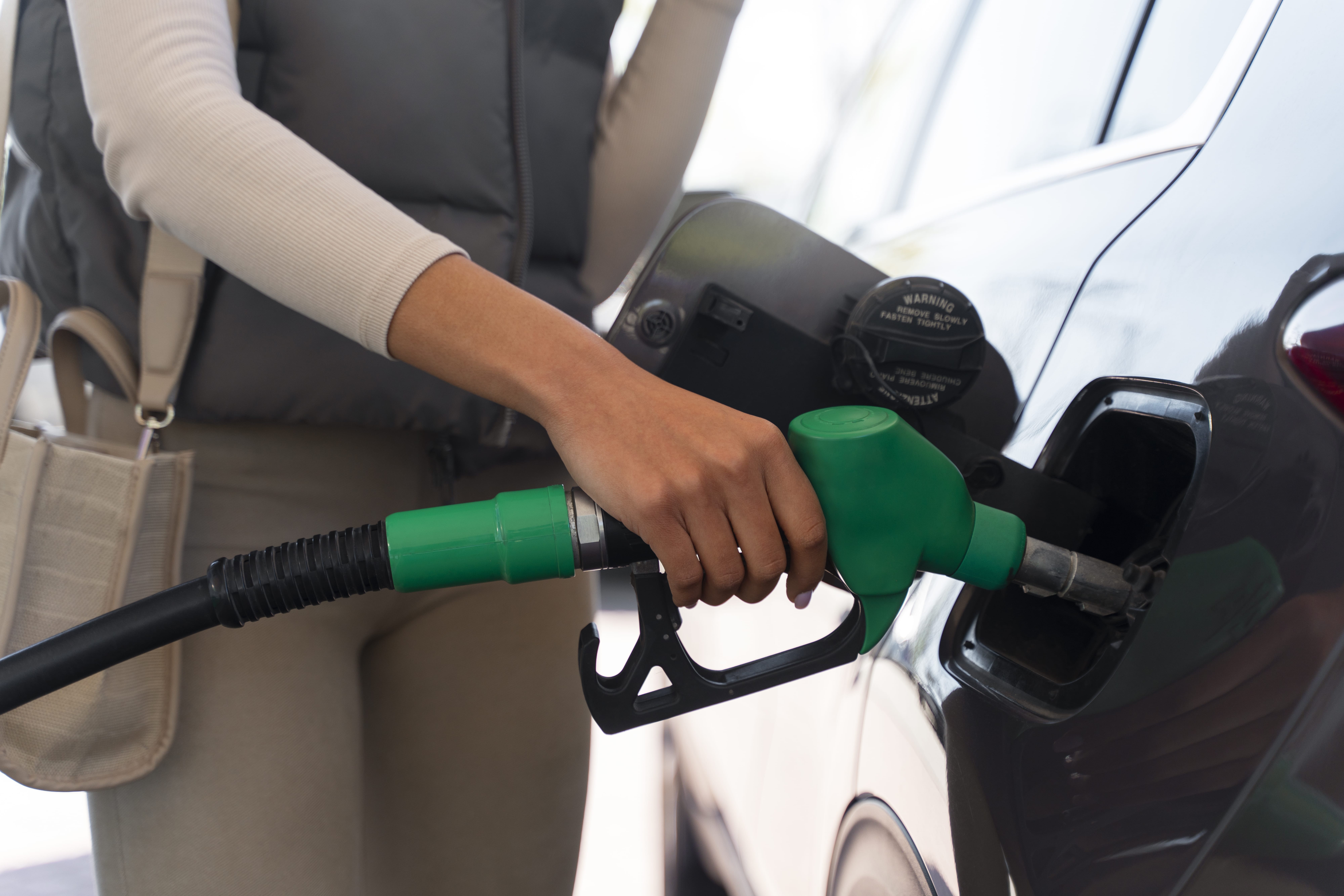 Close-up of a person refuelling a vehicle at a petrol station