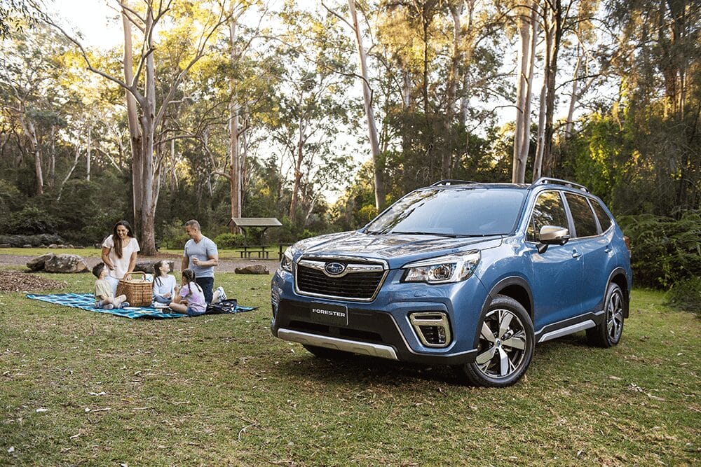 blue Subaru Forester SUV parked outdoors on a sunlit road, showcasing its rugged yet refined design