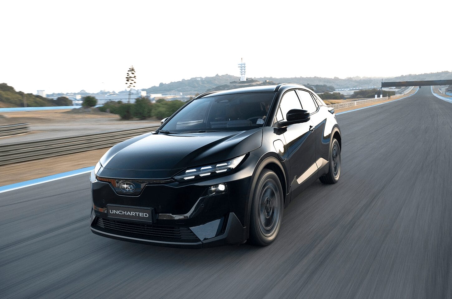 Black Subaru Uncharted driving on a racetrack, highlighting sporty electric SUV performance.