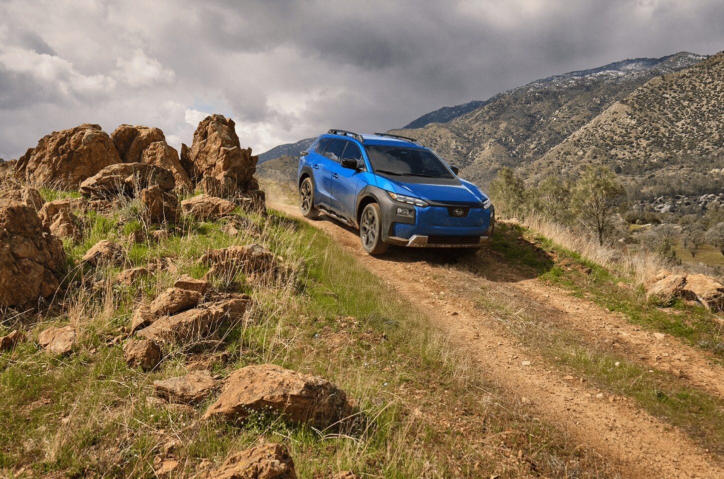 Subaru Trailseeker navigating a rocky off-road trail through mountainous terrain