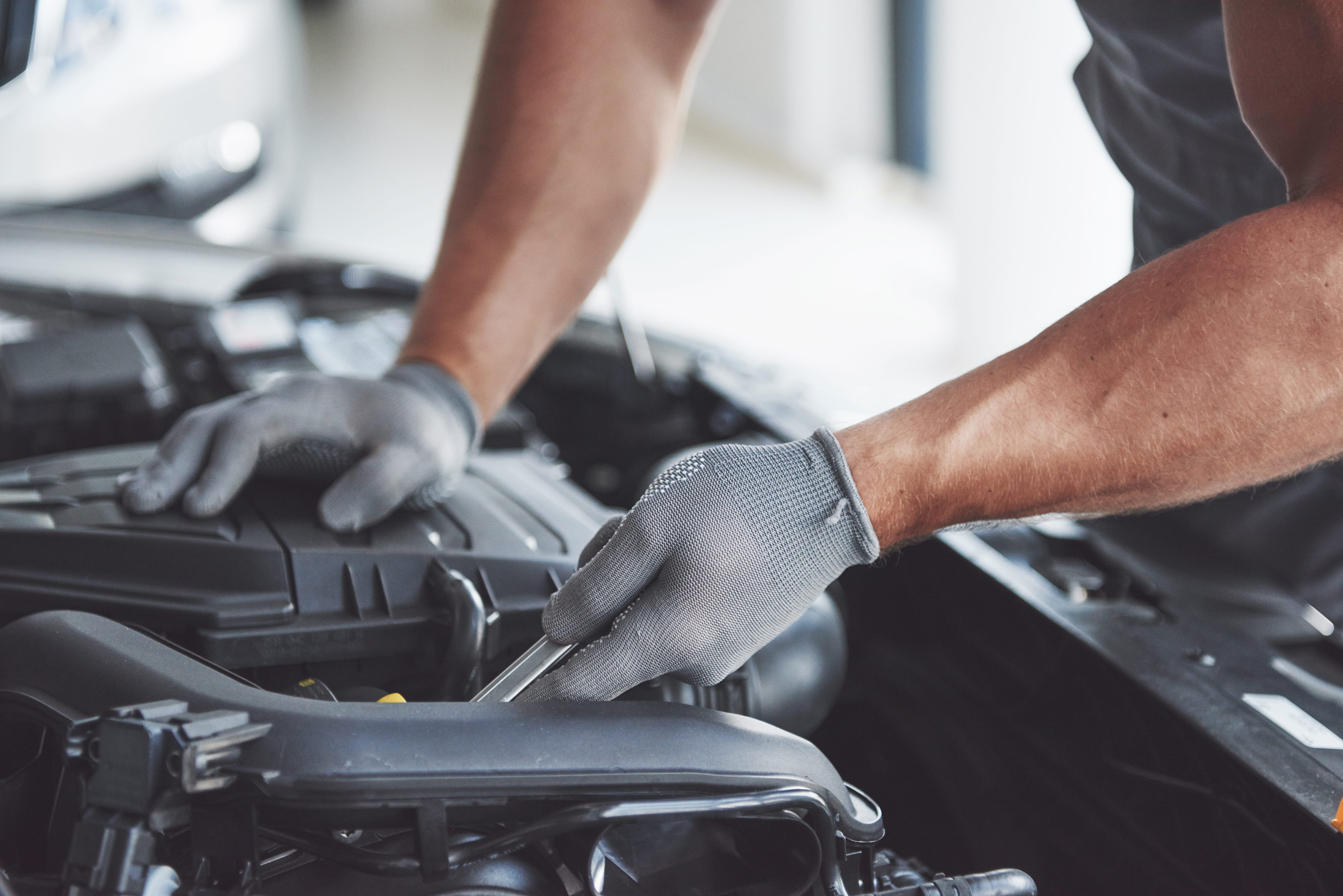 echnician inspecting a vehicle engine during scheduled servicing at a Subaru dealership