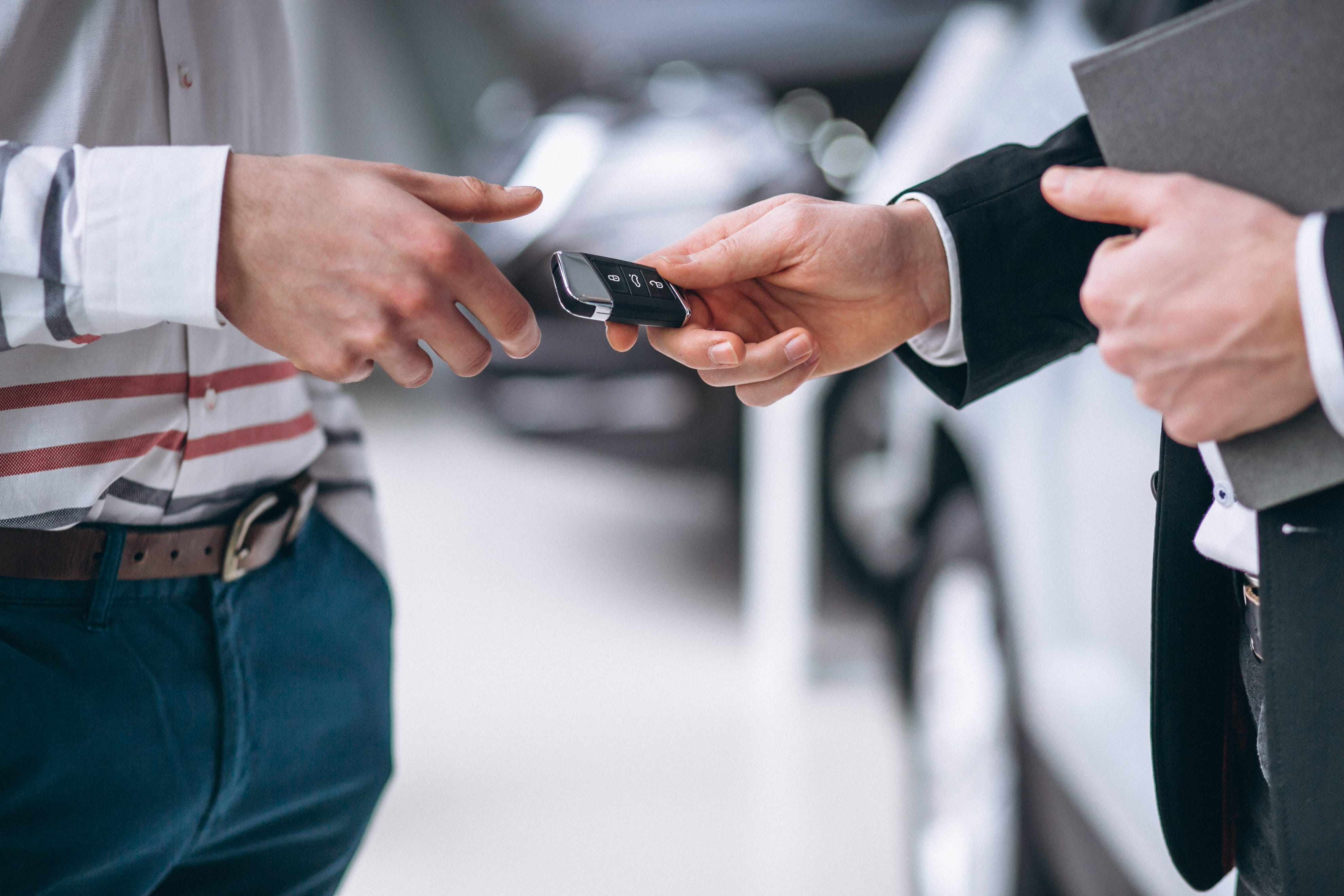 Car key handover between two people at a Perth dealership, representing the trade-in process for a car's trade-in value assessment