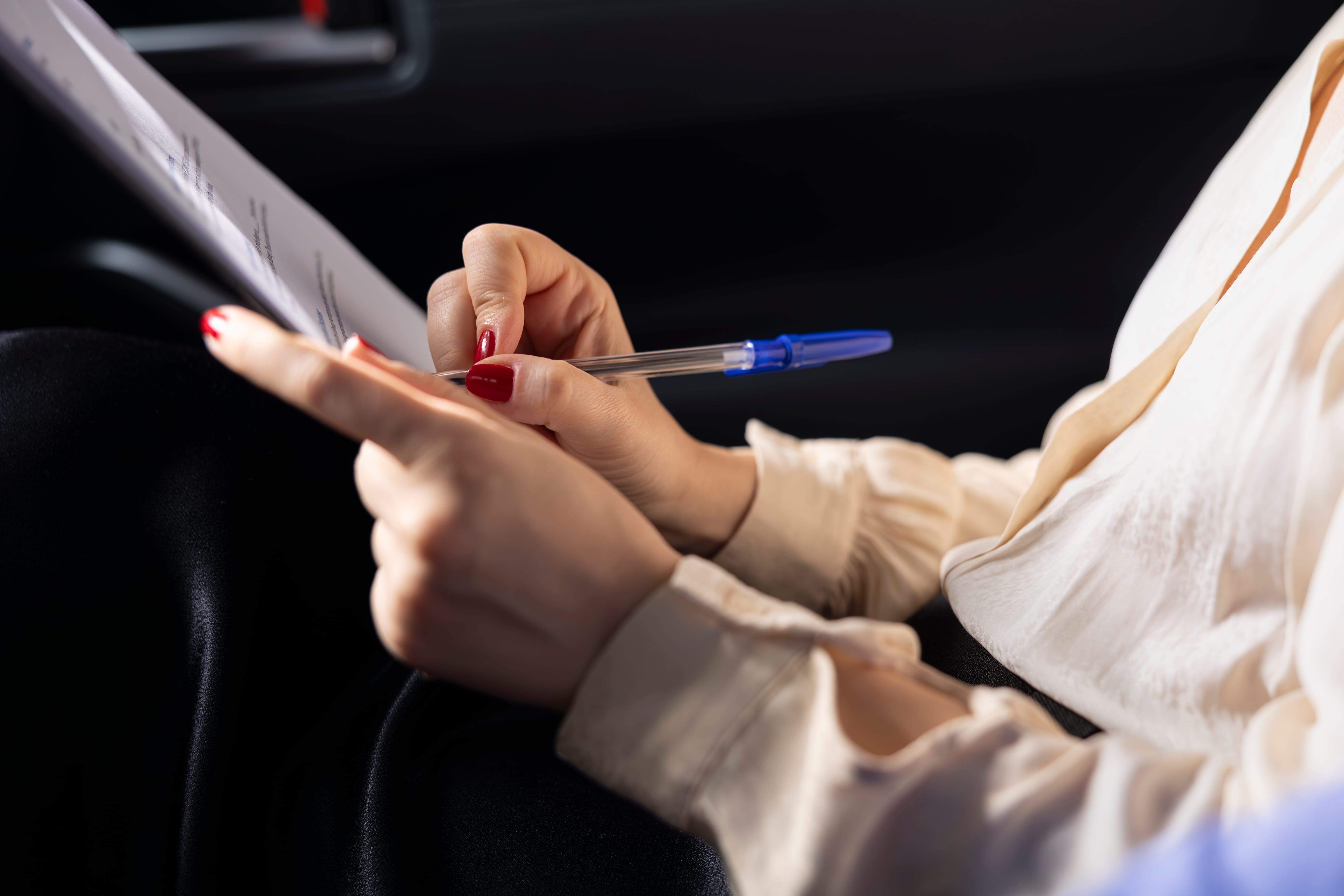 Customer reviewing and signing vehicle handover paperwork before collecting a new car