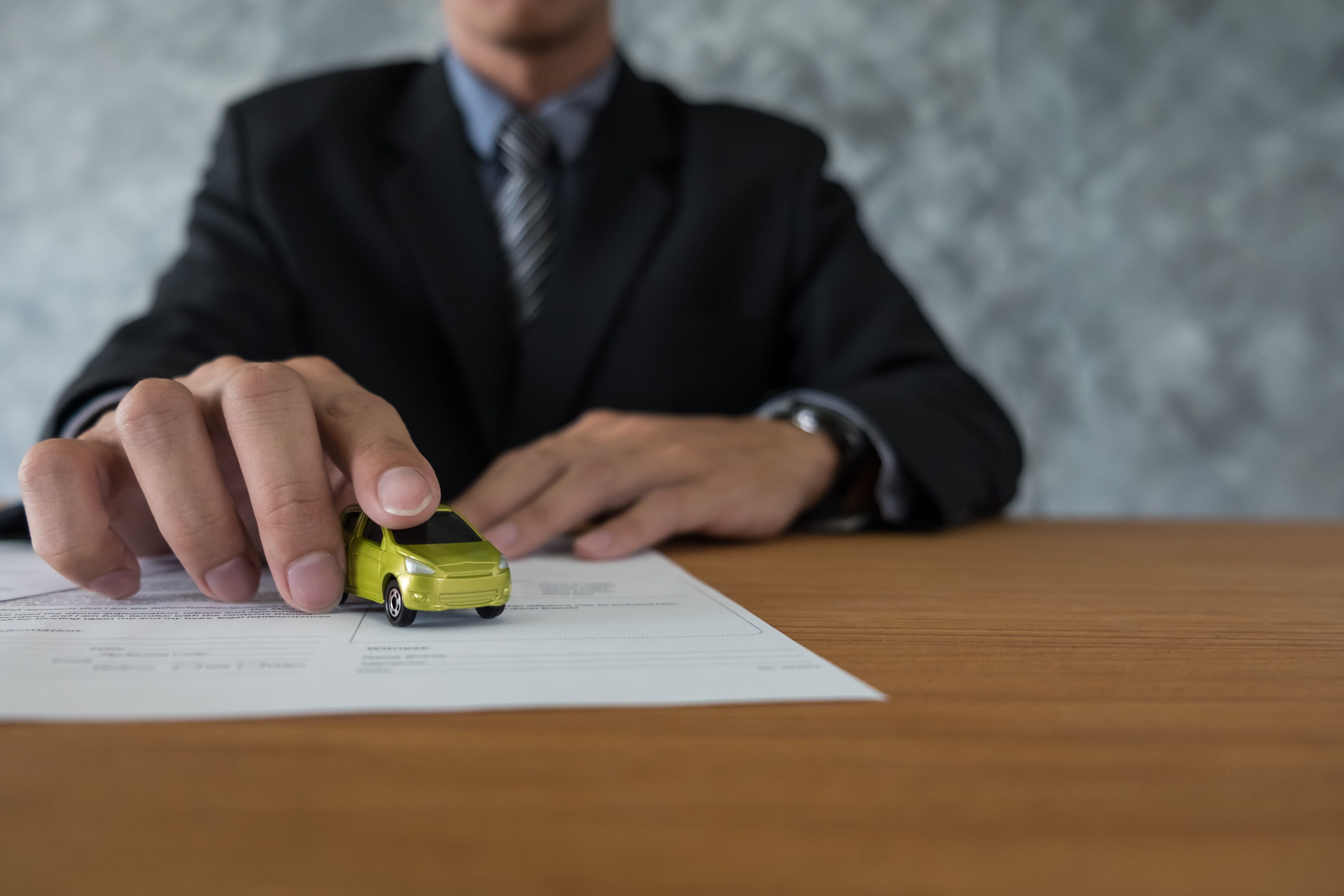 Customer reviewing demo car warranty paperwork with a dealership consultant
